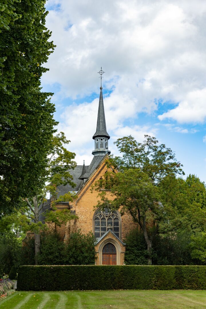 Die Kapelle des Nordfriedhofs, leicht versteckt hinter Baumkronen.