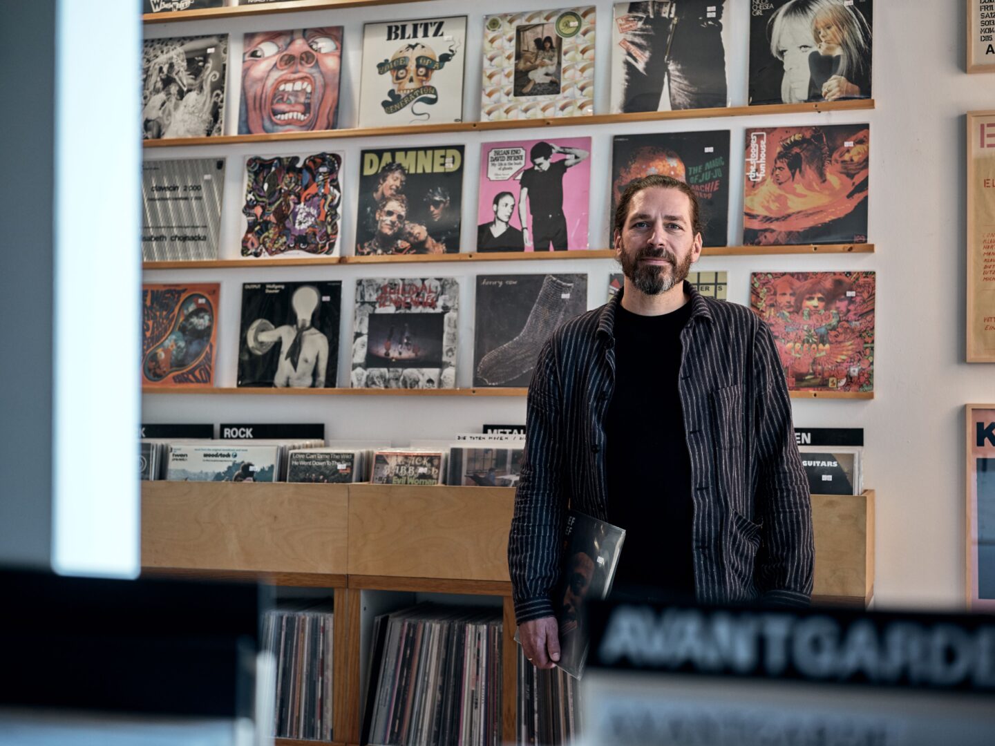 Günter Herke, Inhaber des Plattenladens Minty Vinyl, steht vor seinen Platten im Laden.