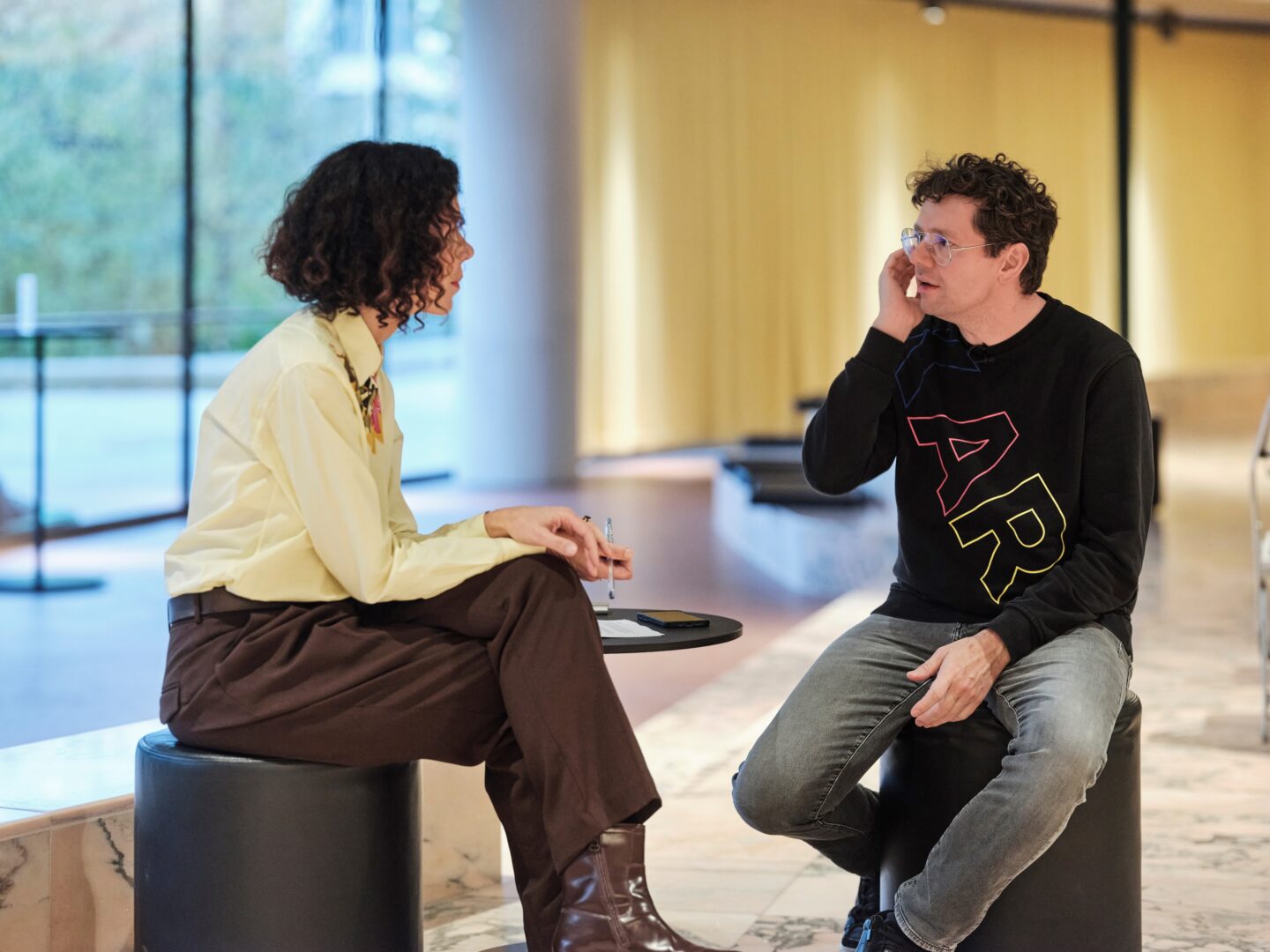 Autorin mit Christian Friedel im Interview. Beide sitzen auf Hockern.
