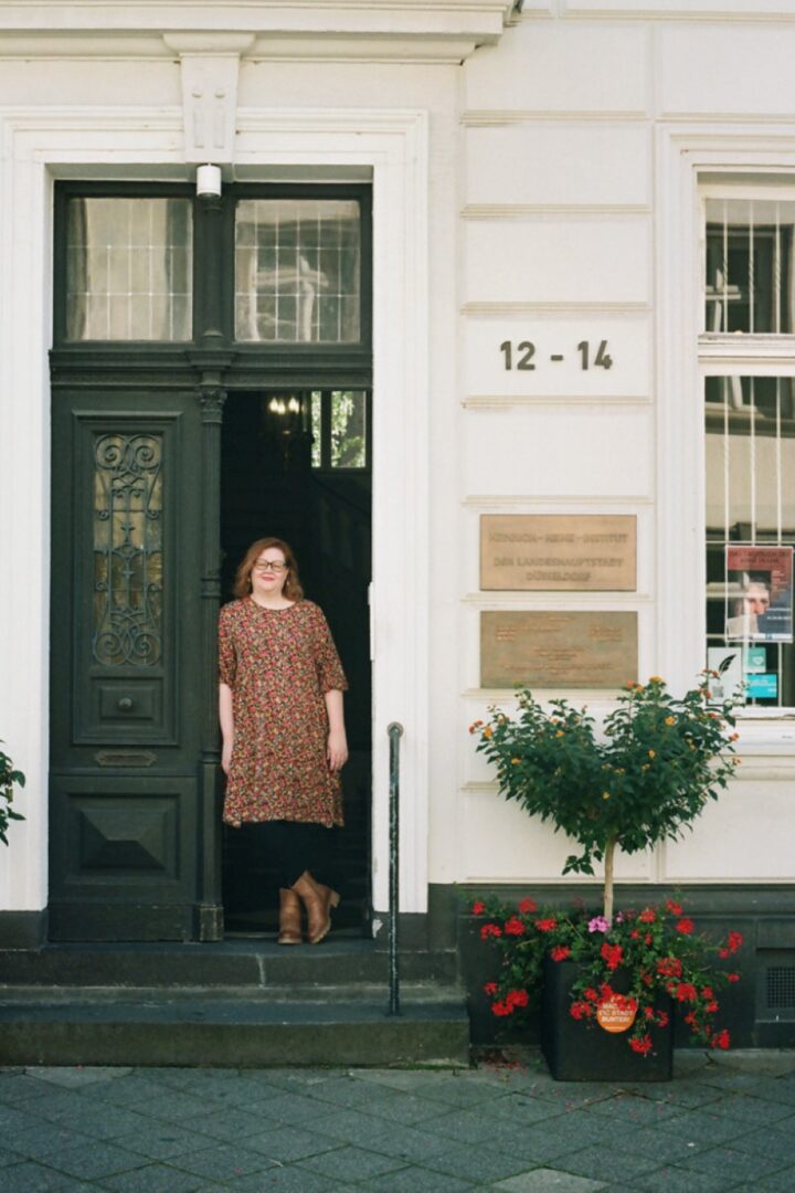Dr. Sabine Brenner-Wilczek vor dem Eingang des Heinrich-Heine-Instituts.