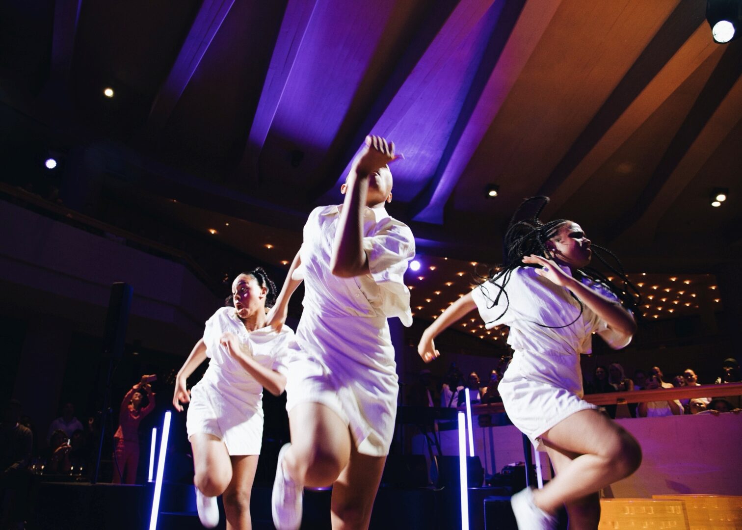 Drei Schwestern in weißen Shorts und Polo tanzen Urban Dance.