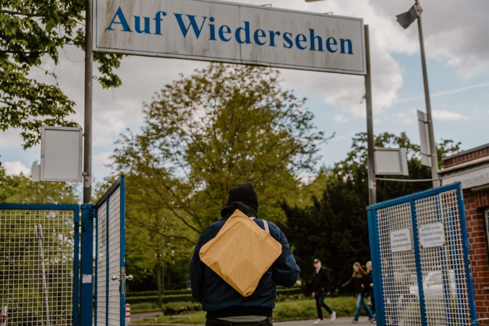 Marcus Haefs verlässt das TuRU-Stadion und geht unter einem Schild, auf dem "Auf Wiedersehen" steht, drunter durch.