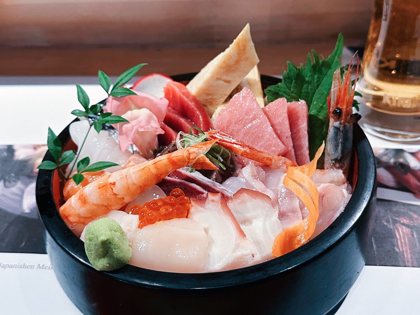 Eine Sushi-Bowl mit Garnele und verschiedene Fischsorten.