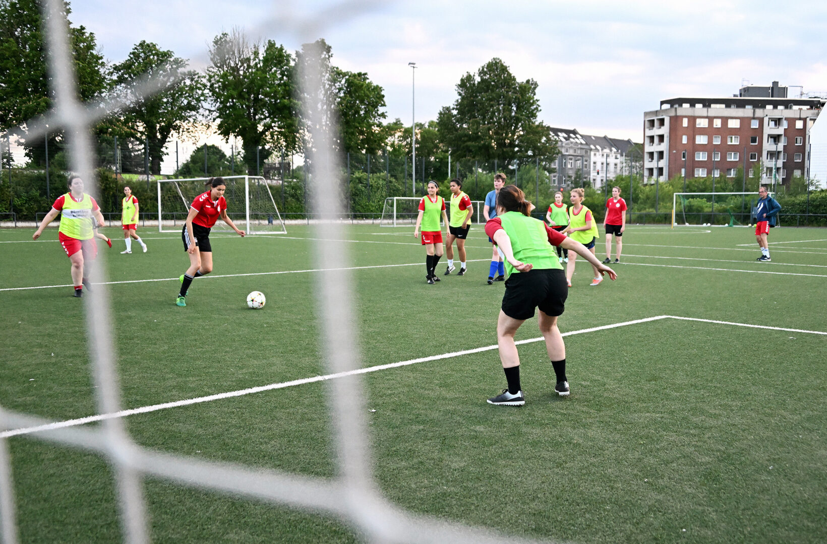 Spielerinnen beim Frauenfußball  Trainingsspiel, Perspektive von hinter dem Tor.