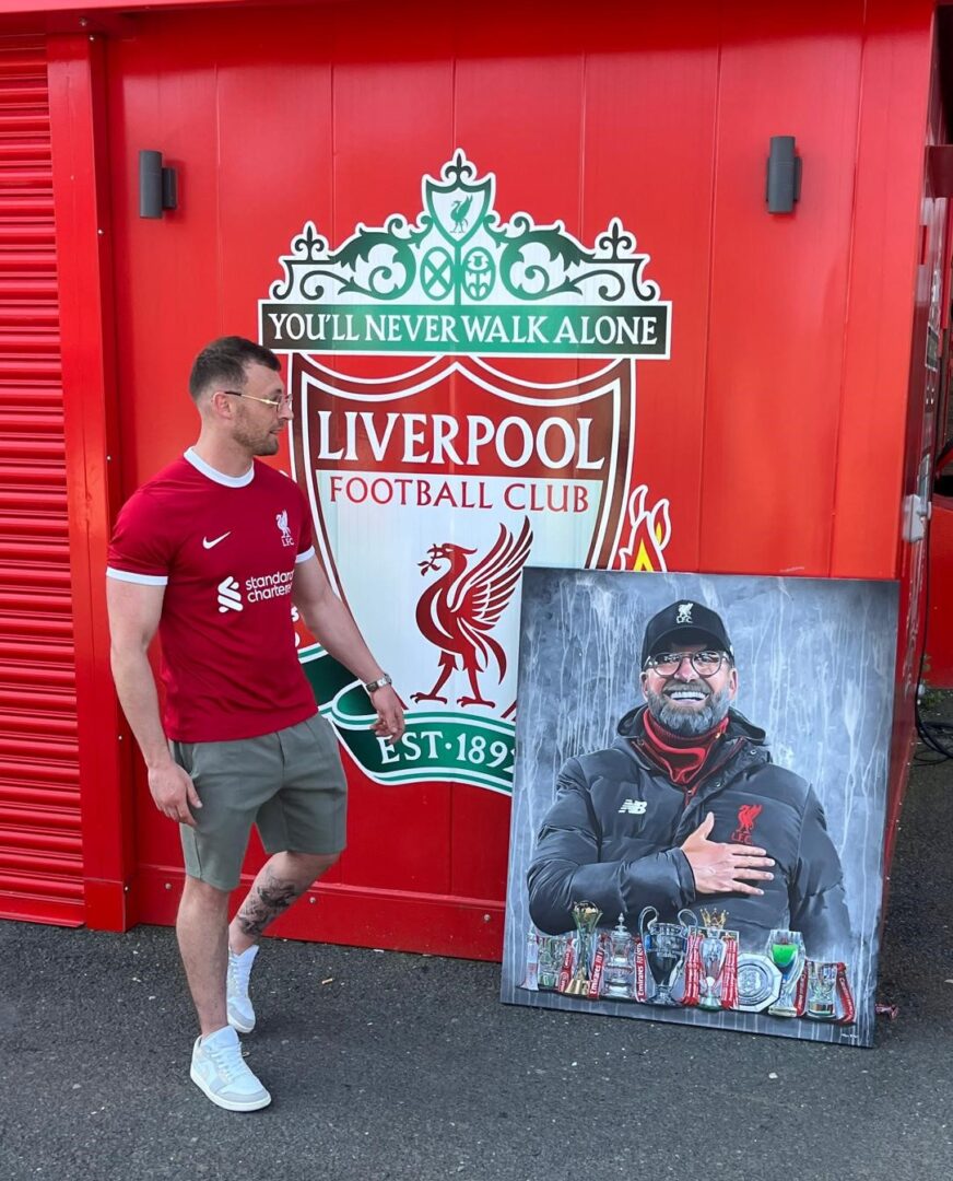 In Liverpool, Fan läuft an Liverpool FC und Bild von Klopp vorbei.