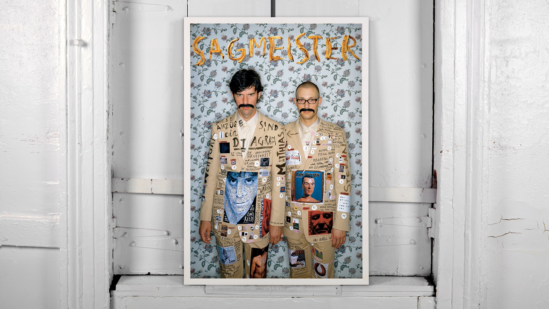 Stefan Sagmeister und Matthias Ernstberger auf einem Poster in wild bedruckten Anzügen.