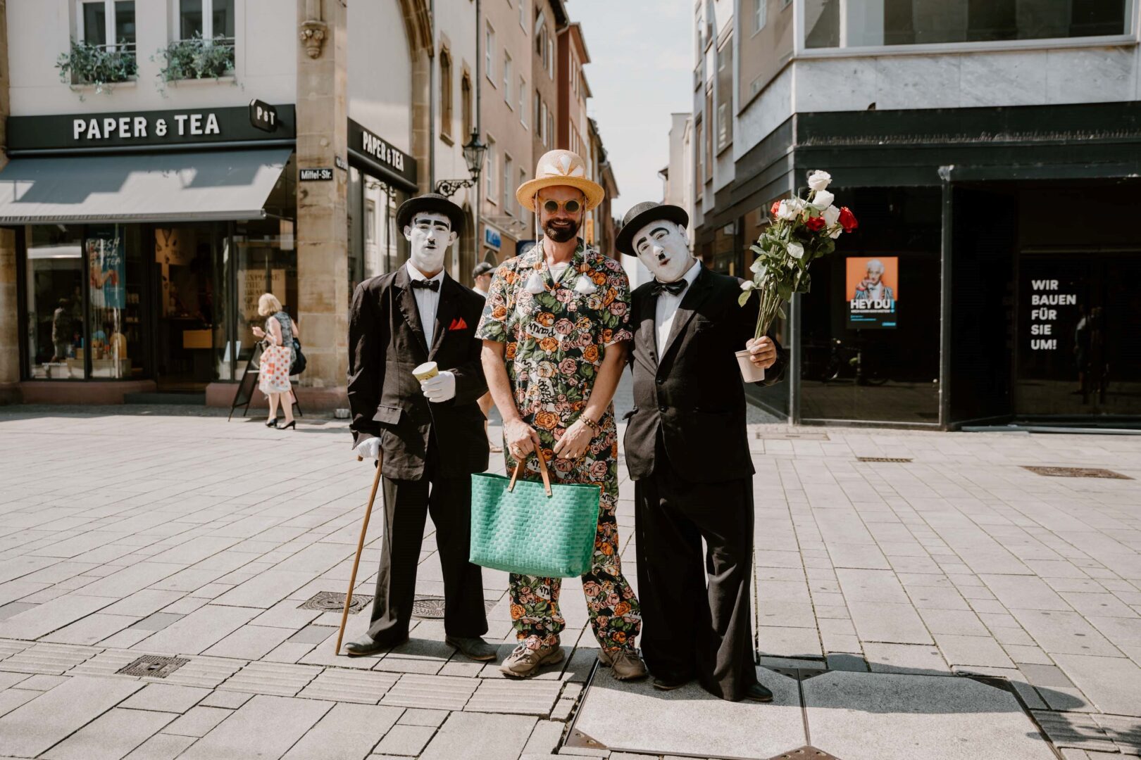 Rolf Buck steht auf der Wallstraße, links und rechts neben ihm je ein Charlie Chaplin Pantomime.