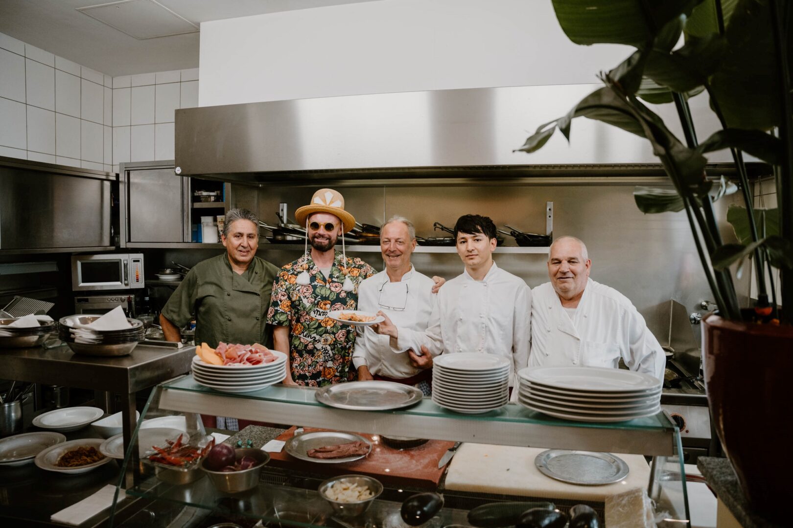 Rolf Buck in der Küche der Trattoria San Leo umringt von vier Köchen.