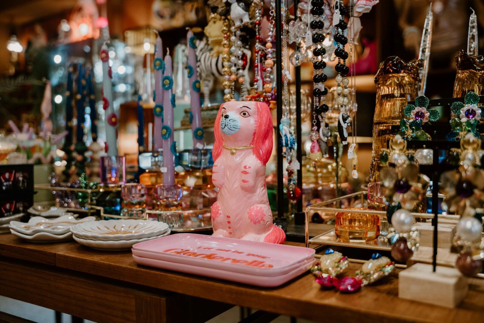 Im Vaseline Store: Ein Verkaufstresen, auf dem eine grell pinke Vase in Form eines Hundes steht, darum herum ist Schmuck in allen Farben und Formen zu sehen.