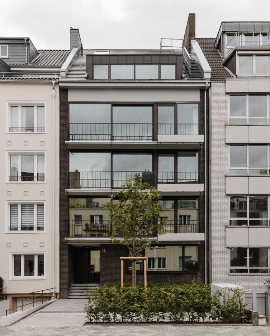 Haus, dessen Front was ausschließlich aus bodentiefen Fenstern zu bestehen scheint.