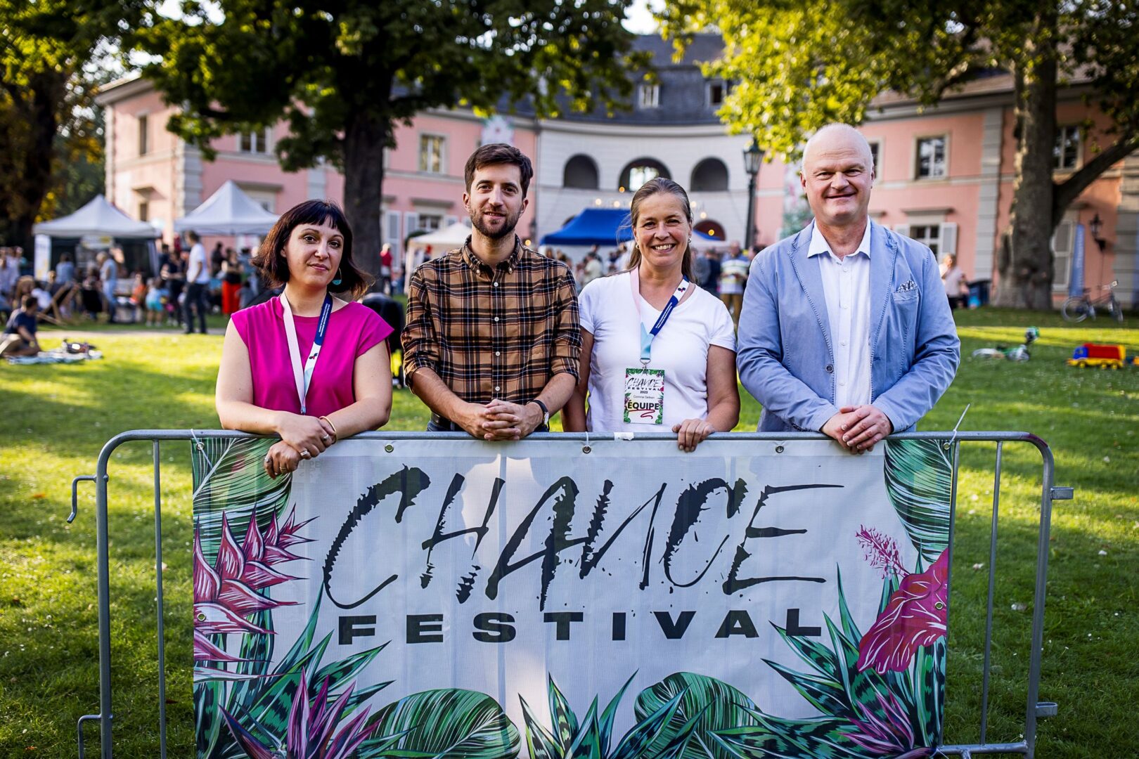 Man sieht vier Personen, die das Chance Festival-Banner halten. Im Hintergrund das Theatermuseum.