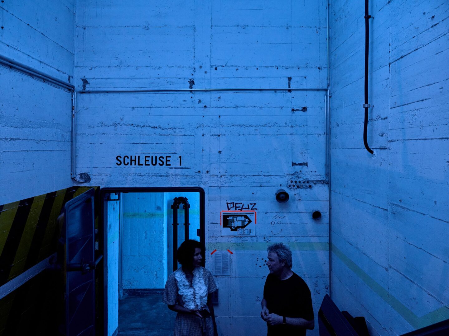 Ein in lilablaues Licht getauchter Treppengang im Bunker.