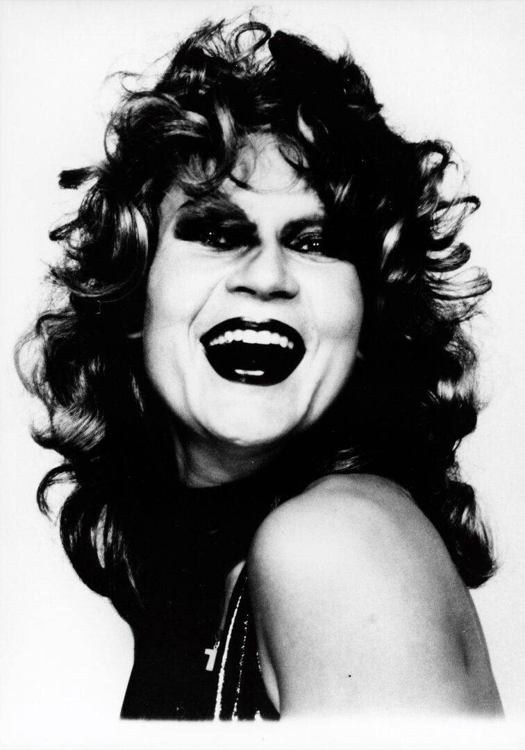 Die junge Katharina Sieverding im Selbstportrait mit Locken und Lachen.