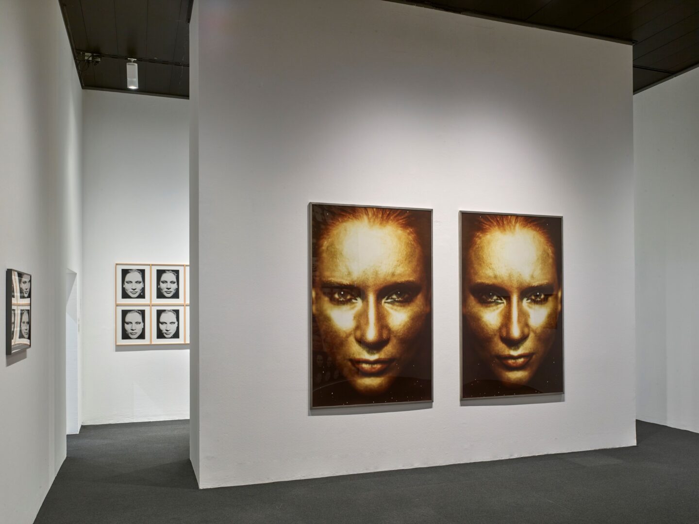 Installationsansicht der Ausstellung von Katharina Sieverding. Man sieht zwei gleiche Portraits im Hochformat nebeneinander und den Raum.