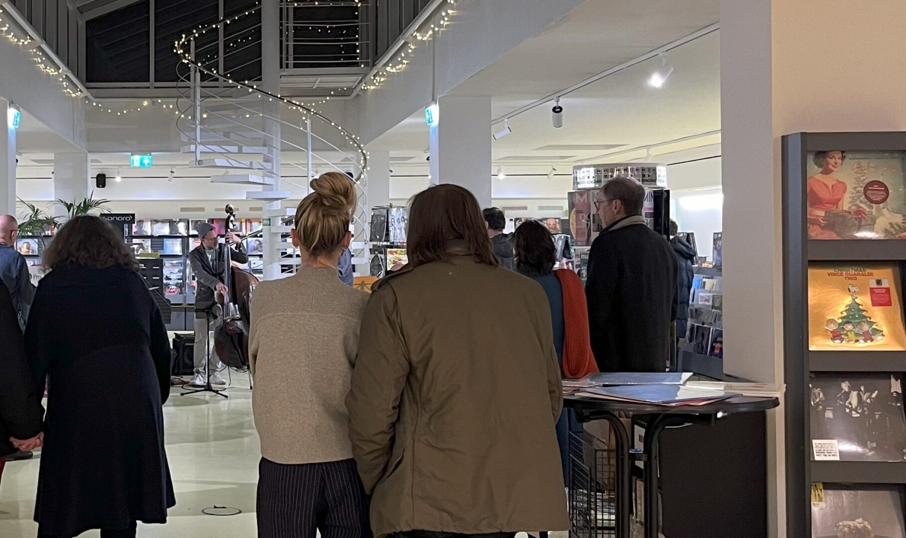 Axel Fischbacher bei A&O Medien. Man sieht Publikum von hinten und am Ende etwas kleiner den Musiker.