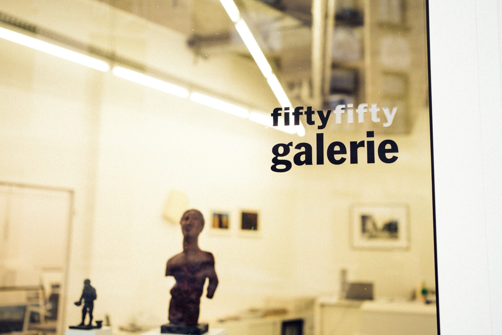 Schaufenster der Galerie, rechts oben steht "fiftyfifty galerie", drinnen sieht man Kunst.