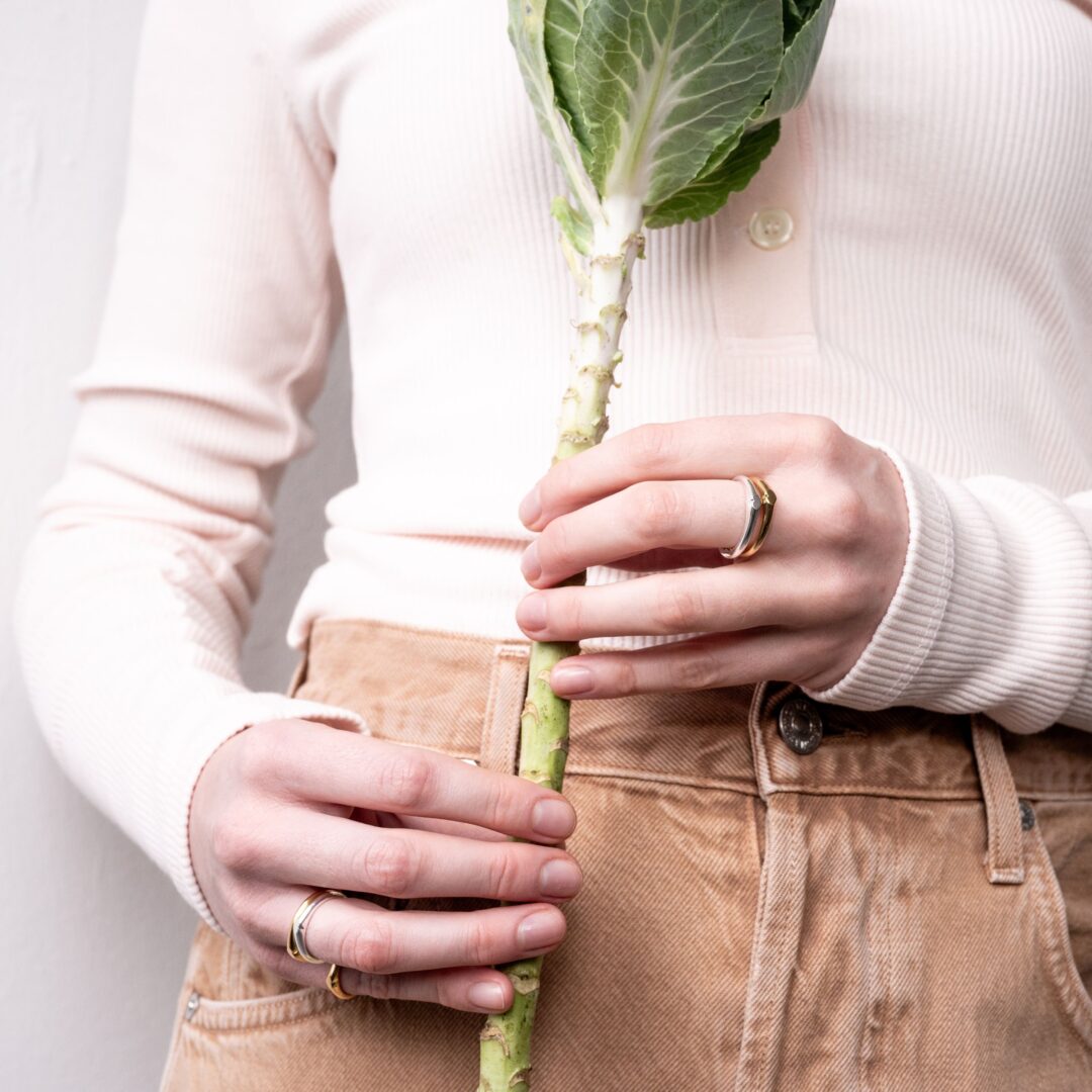 Man sieht zwei Fotos: links: drei Frauen vor ihrem Schmuckladen und rechts halten zwei beringte Hände einen Blumenstiel.
