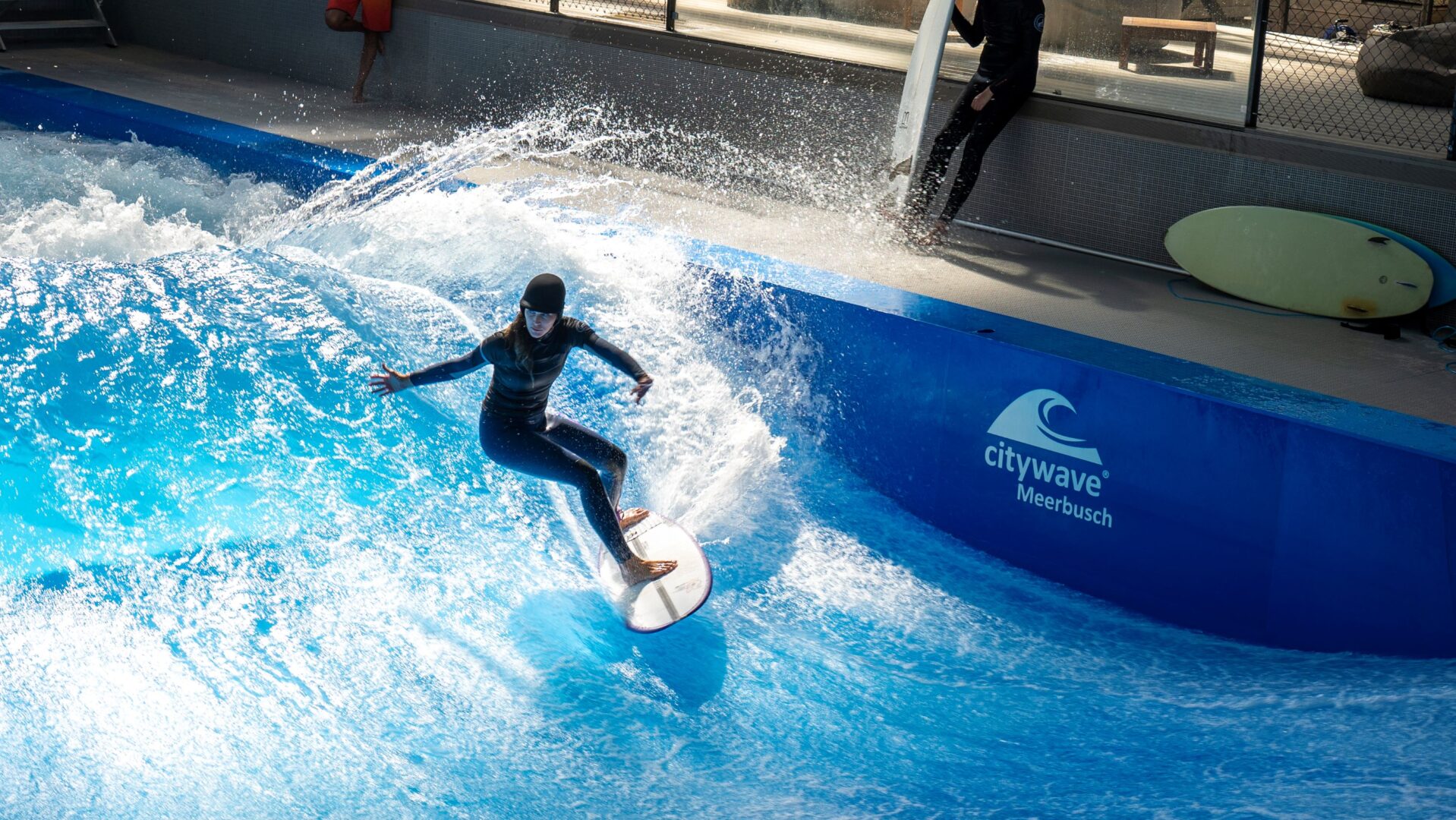 Indoor Surfen: Man sieht eine Person eine Welle surfen.