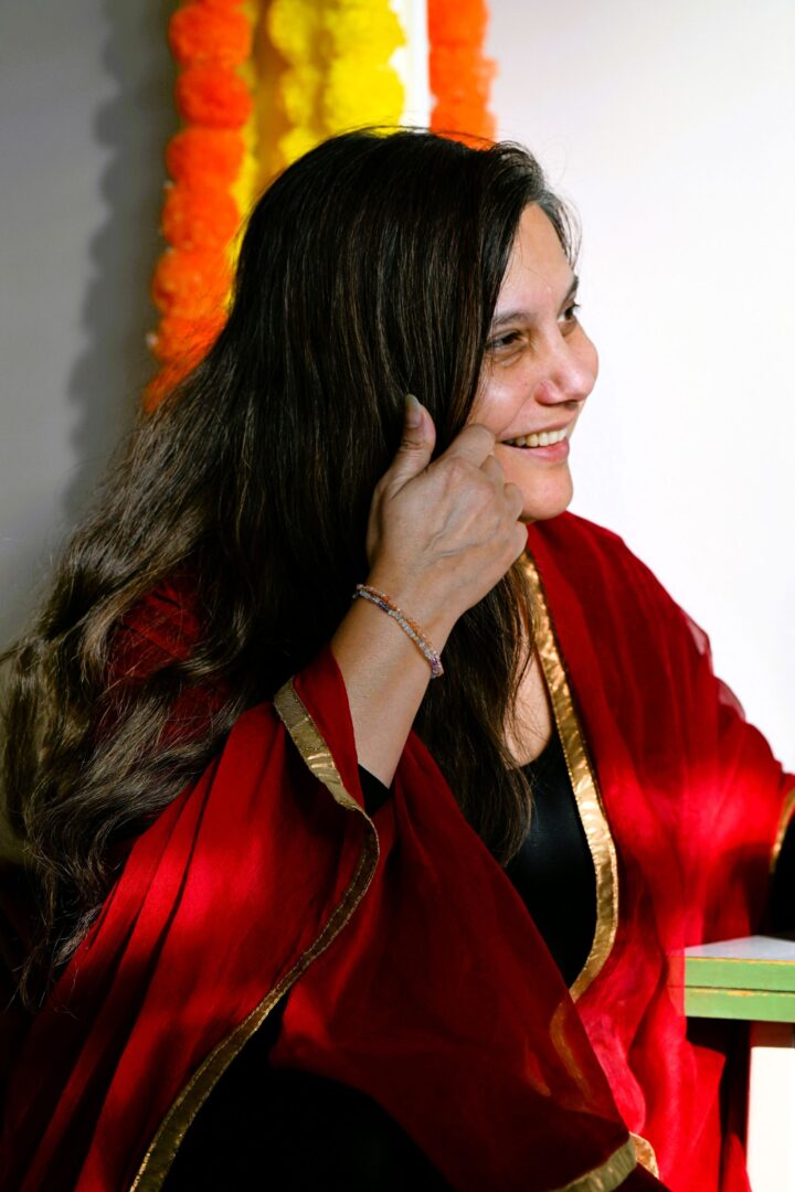 Mithu Sanyal im leichten Profil streicht sich die Haare aus dem Gesicht.