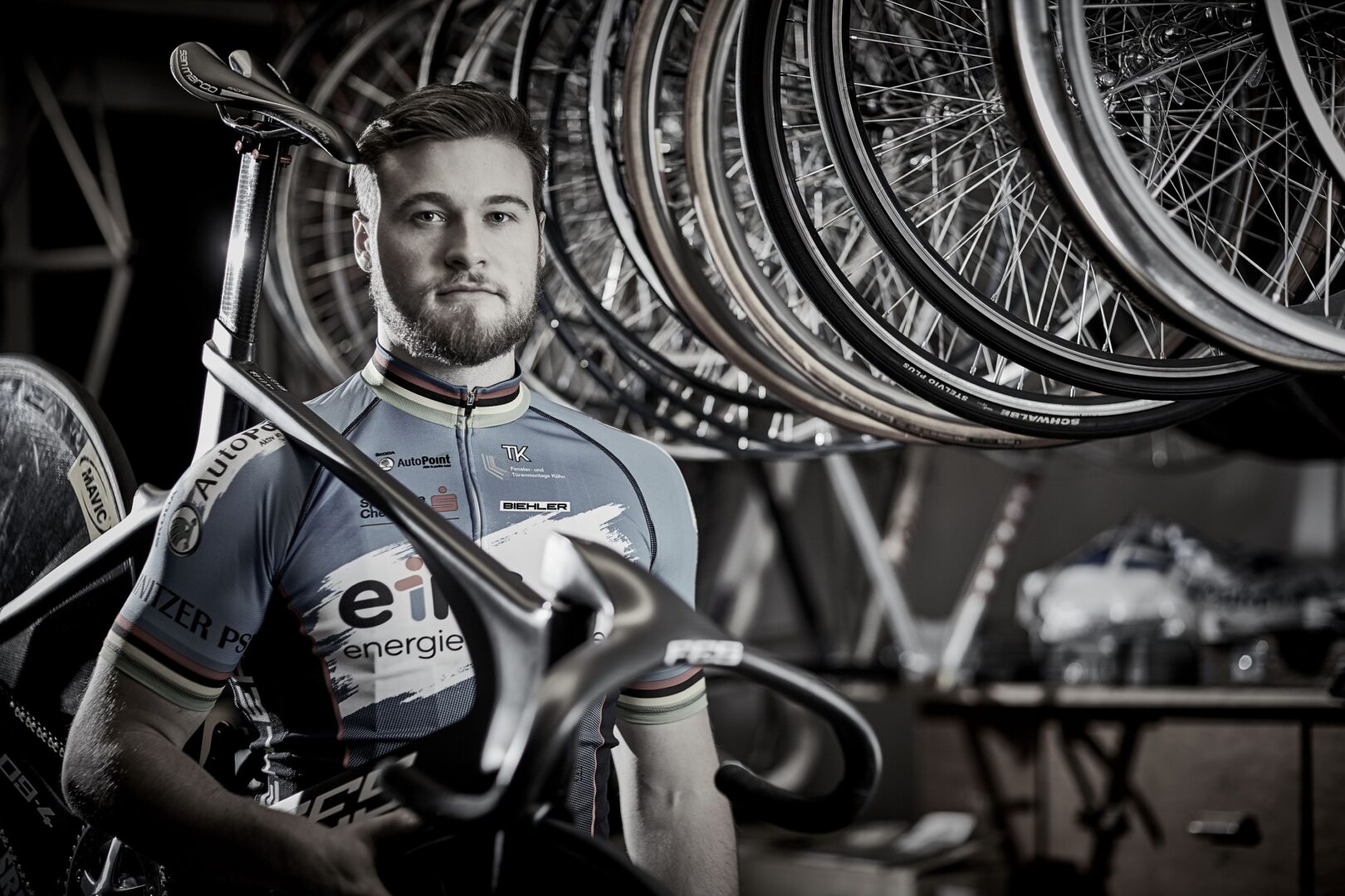 Bahnradweltmeister und Olympiateilnehmer Stefan Bötticher vor einer Reihe von Fahrrädern. 