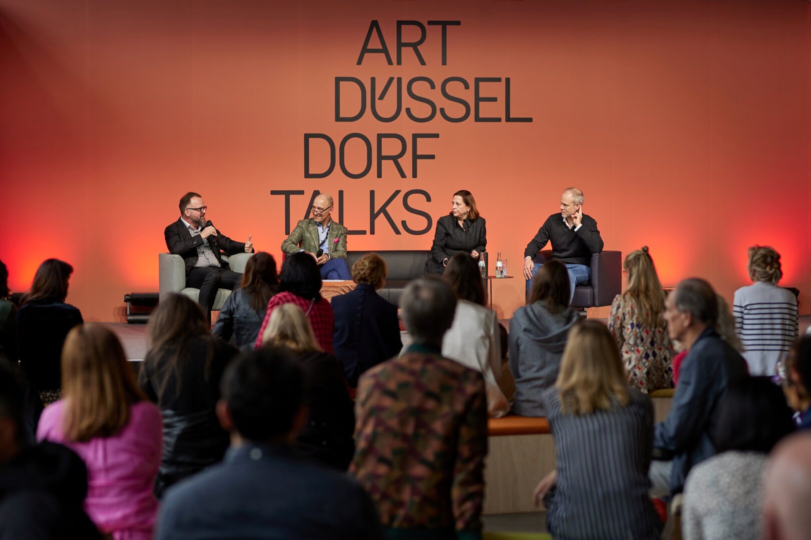 Man sieht die besetzte Talk-Bühne der Art Düsseldorf mit Publikum im Vordergrund.