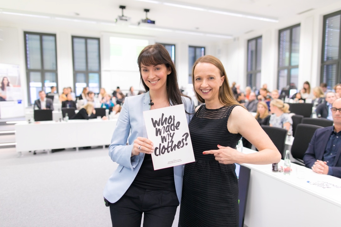 Monika Hauck (links) und Anja Gräf, City Ambassadors Fashion Revolution Düsseldorf, halten gemeinsam ein Schild mit dem Slogan "Who made my clothes?".