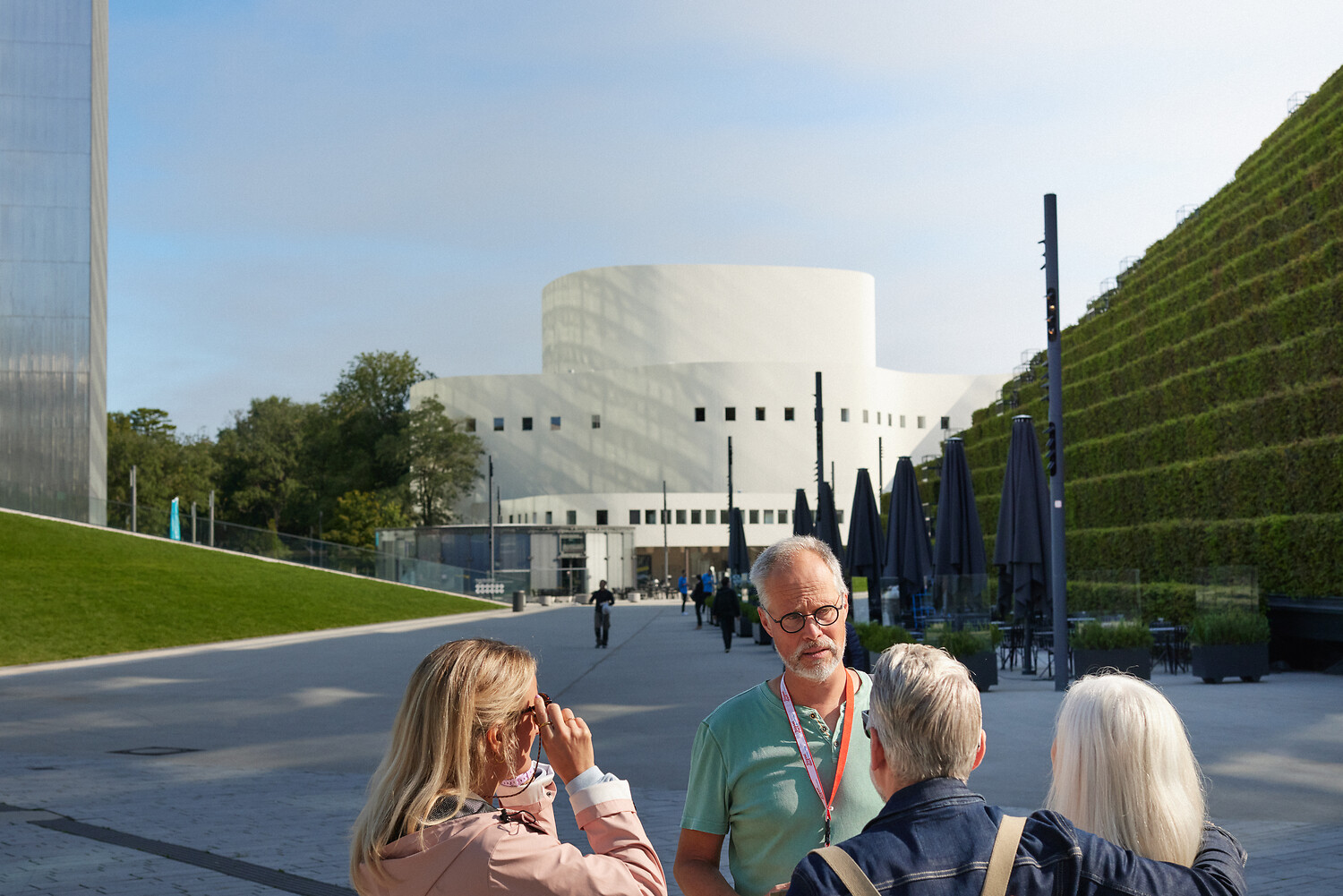 Im Hintergrund sieht man das Schauspielhaus zwischen Kö-Bogen II (re) und Dreischeibenhaus. Vorne stehen vier Personen, die am Klimaspaziergang teilnehmen.