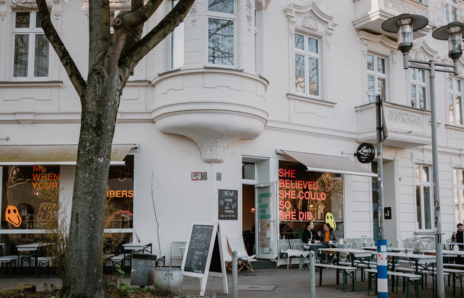 Man sieht Lina's Coffee von außen und die Bürgersteigterrasse, wo man sitzen kann.