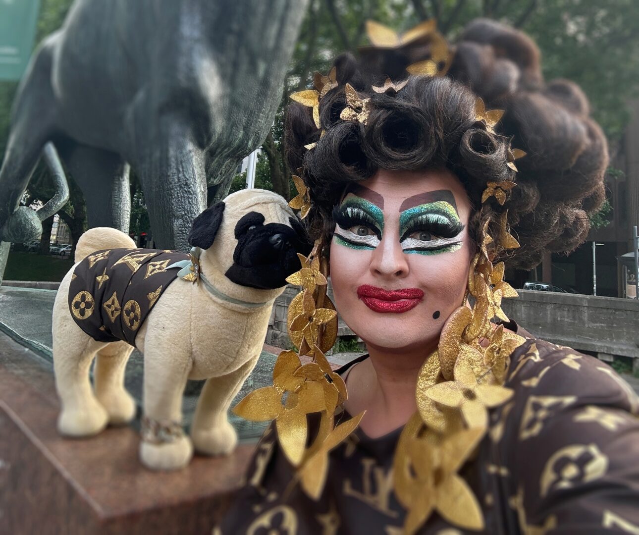 Portrait der Dragqueen Freifrau von Kö mit ihrem Stoffhund. Beide tragen Fake-Louis-Vuitton