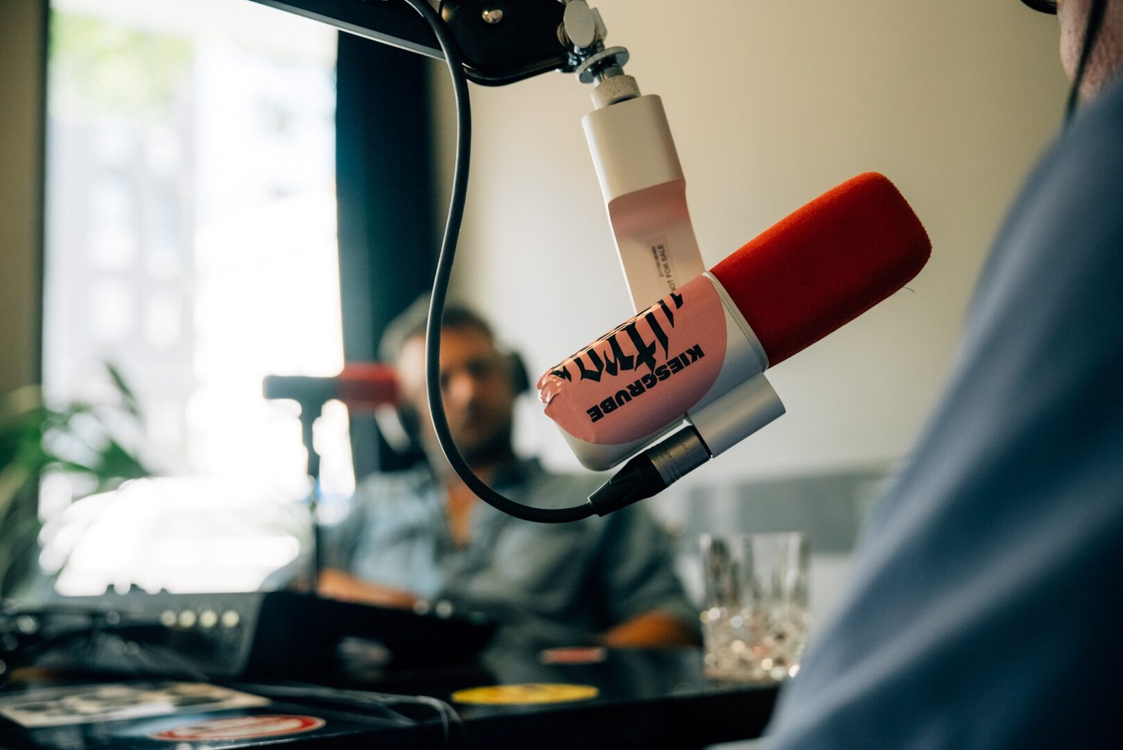 Im Büro von Tom Preuss, Macher der Kiesgrube. Im Vordergrund ein Mikrofon mit großem Aufkleber, auf dem Kiesgrube steht.