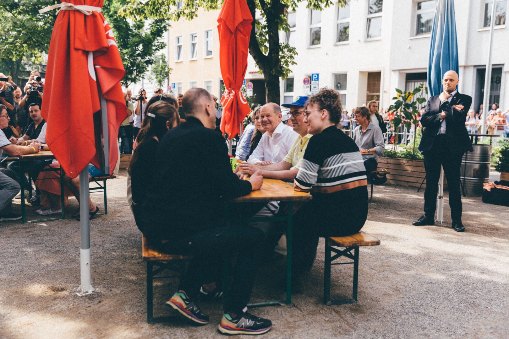 Büdchentag 2023: Olaf Scholz sitzt mit den Organisator*innen an einem Biertisch.