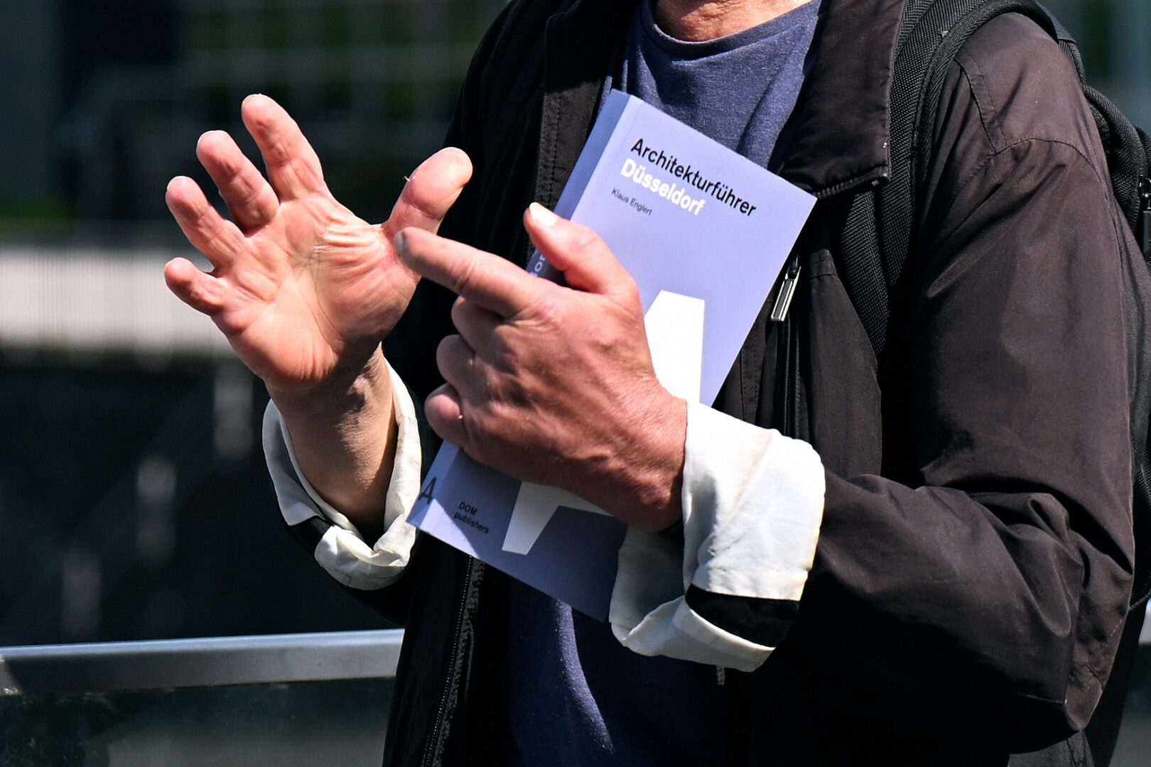 Man sieht gestikulierende Männerhände. 