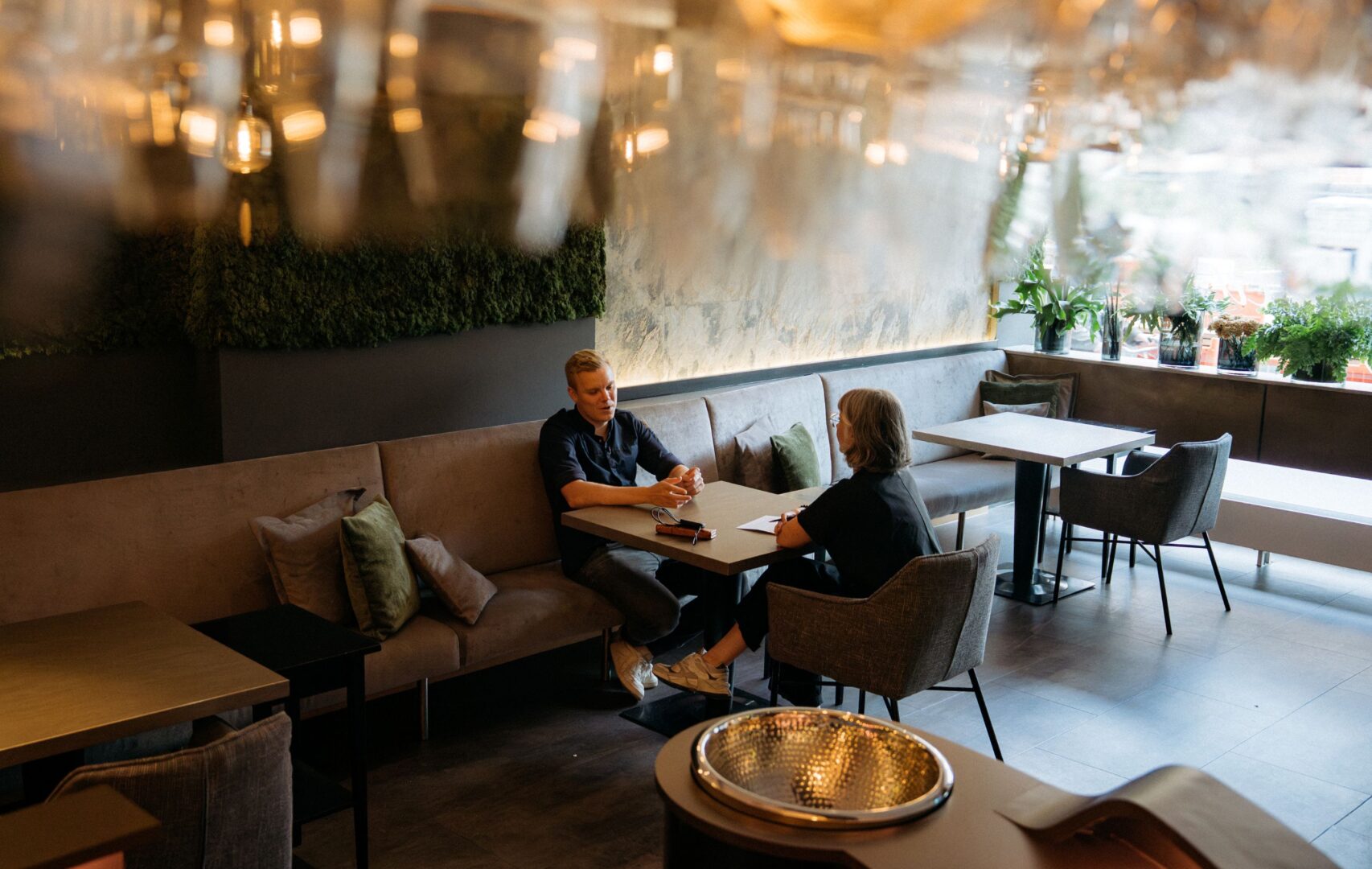 Jaspar Wcislo und Cynthia Blasberg (Autorin) führen das Interview an einem Tisch im Restaurant. Das Foto ist von schräg oben aufgenommen.