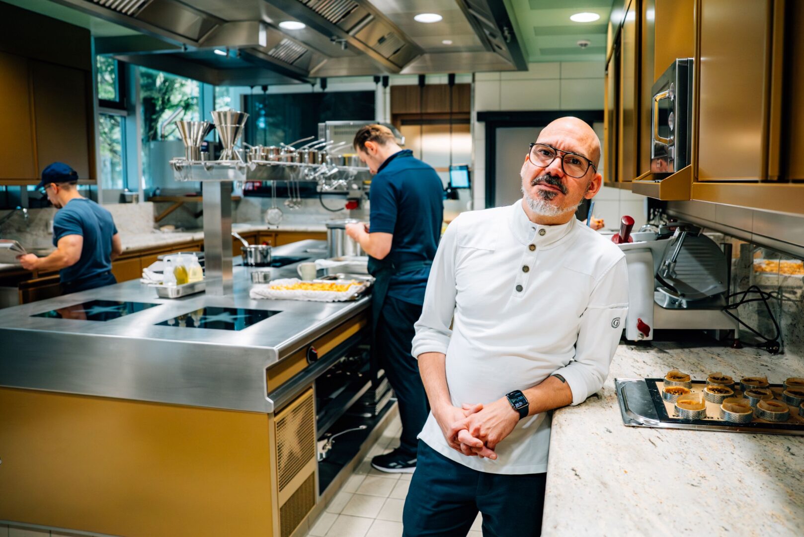 Timo Fritsche, Küchenchef des Restaurants La Vie by Thomas Bühner, steht in der Küche angelehnt an eine Anreichte.