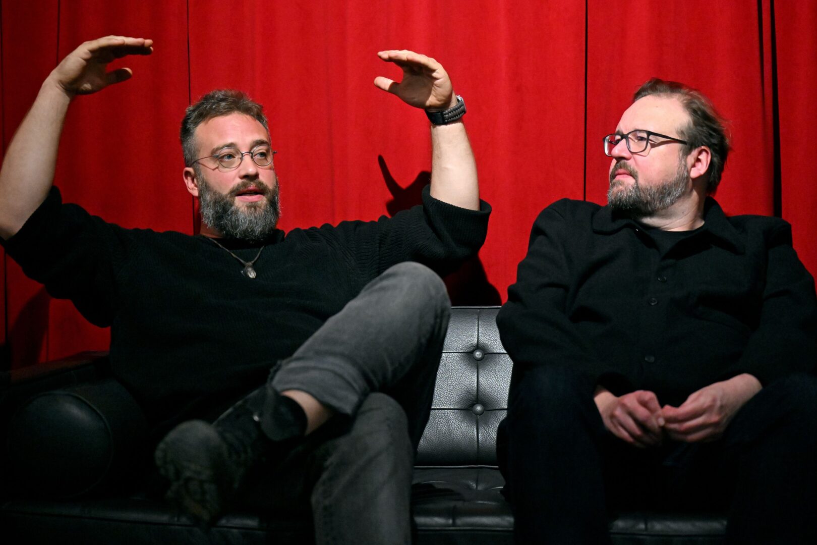 Nico und Eric sitzen nebeneinander. Nico (links) erzählt mit großen Gesten.