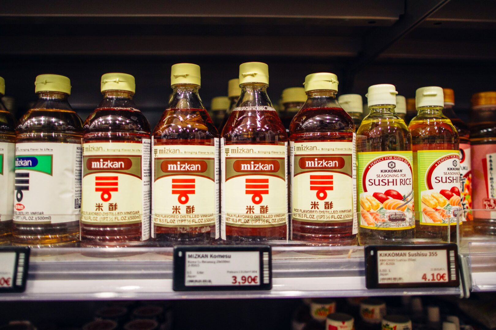 Man sieht eine Nahaufnahme von Reisessig in einem Regal im Supermarkt.