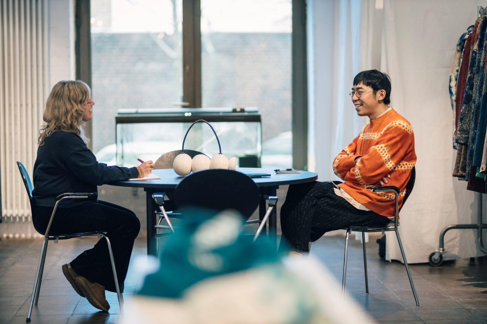 Karolina Landowski (li) und Hiro sitzen während des Interviews an einem Tisch im Atelier von Suzusan. 