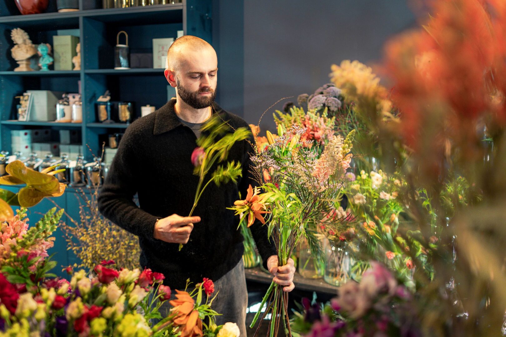 Victor Breuer bei der Arbeit, man sieht ihn inmitten von Blumen, aus denen er auswählt.