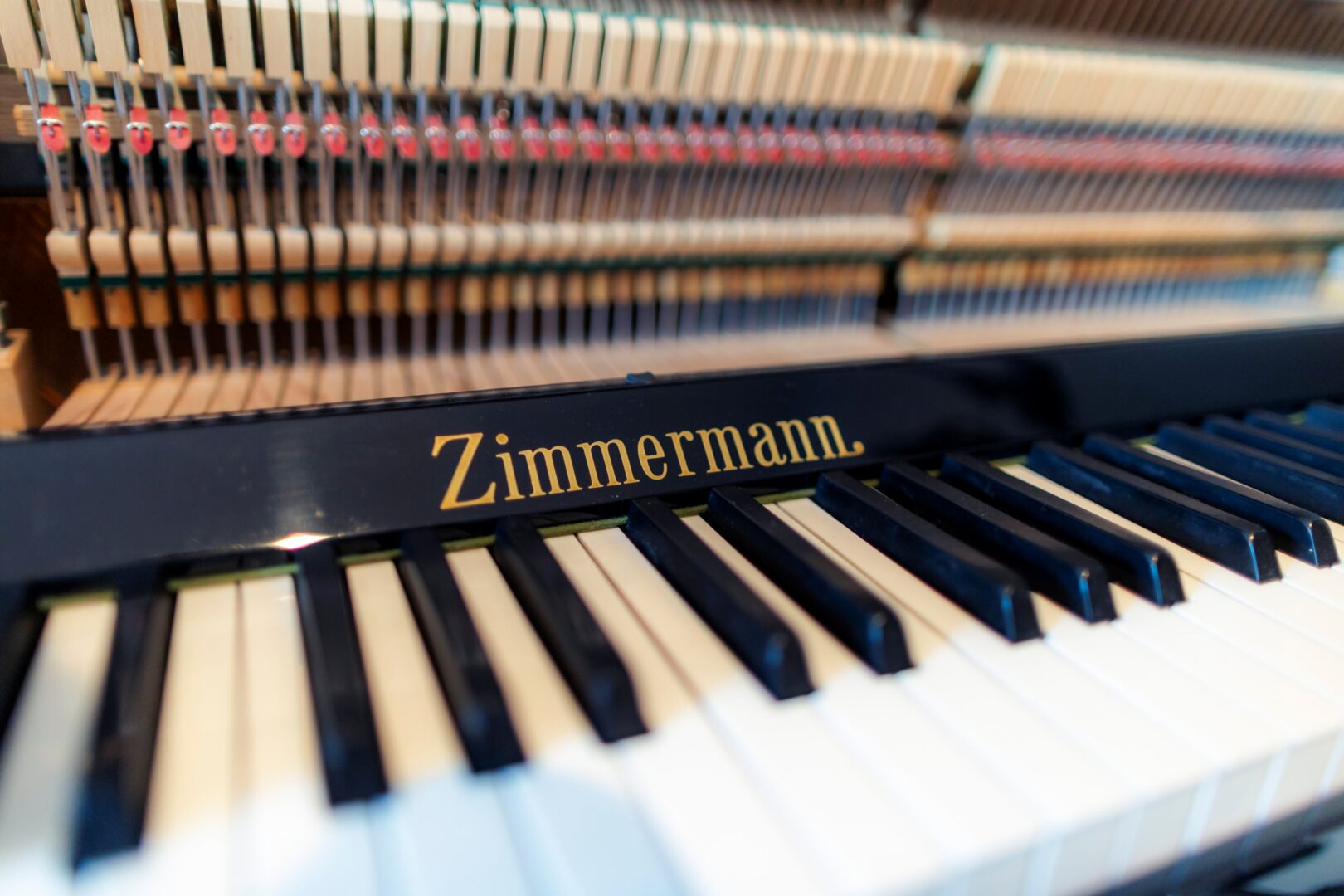 Man sieht die Tastatur eines Klaviers der Marke Zimmermann. Der Schriftzug ist ebenfalls zu sehen. 