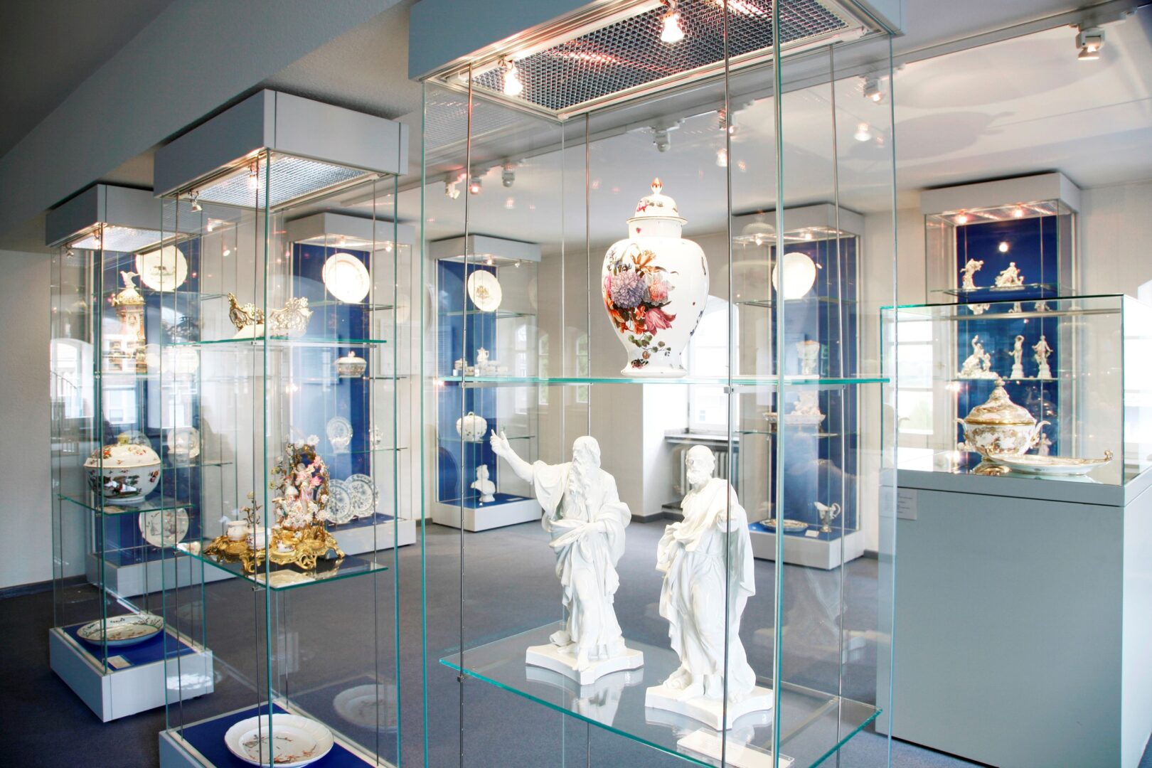 Ausstellungsansicht im Hetjens Museum, man sieht einen Raum mit vielen Vitrinen, in denen Porzellanfiguren stehen.