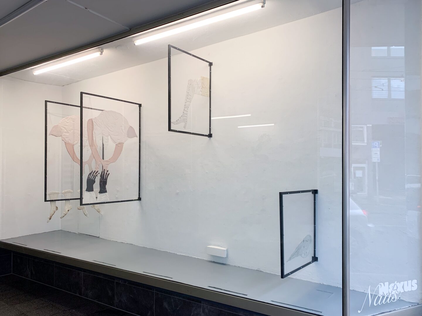Man sieht eine große Vitrine, in der Kunstwerke hängen.