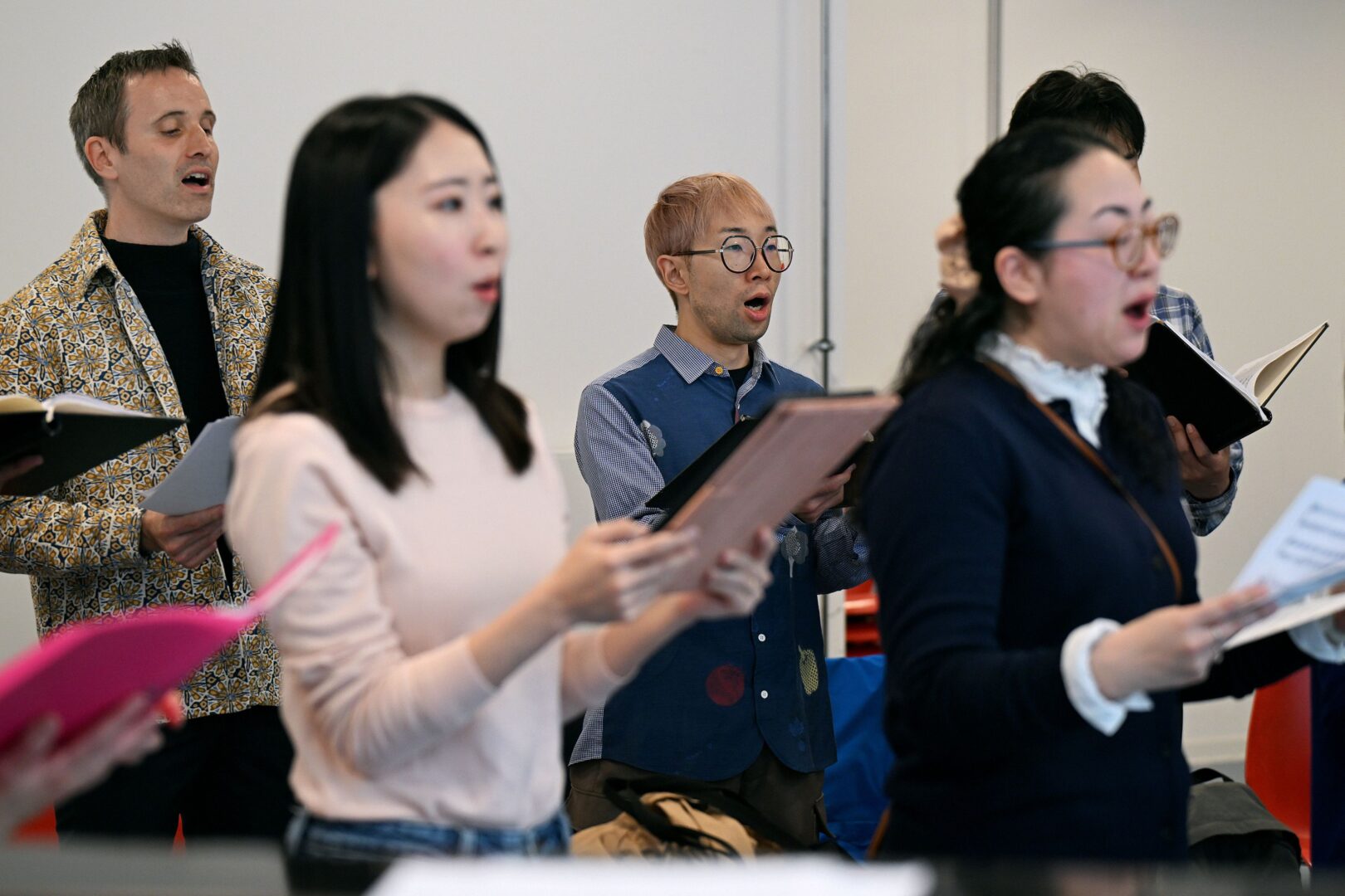 Der japanische Chor Düsseldorf in Little Tokyo. Man sieht, versetzt stehend, vier Chormitglieder bei der Probe singend.