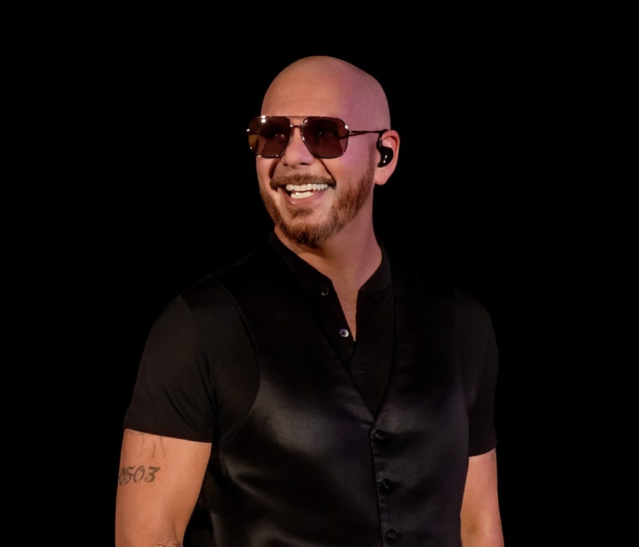 Konzerte in Düsseldorf: Pitbull steht schwarz gekleidet vor einem schwarzen Hintergrund.